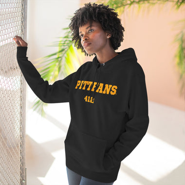Person wearing a black hoodie with 'PITTFANS' text, standing indoors with plants in the background
