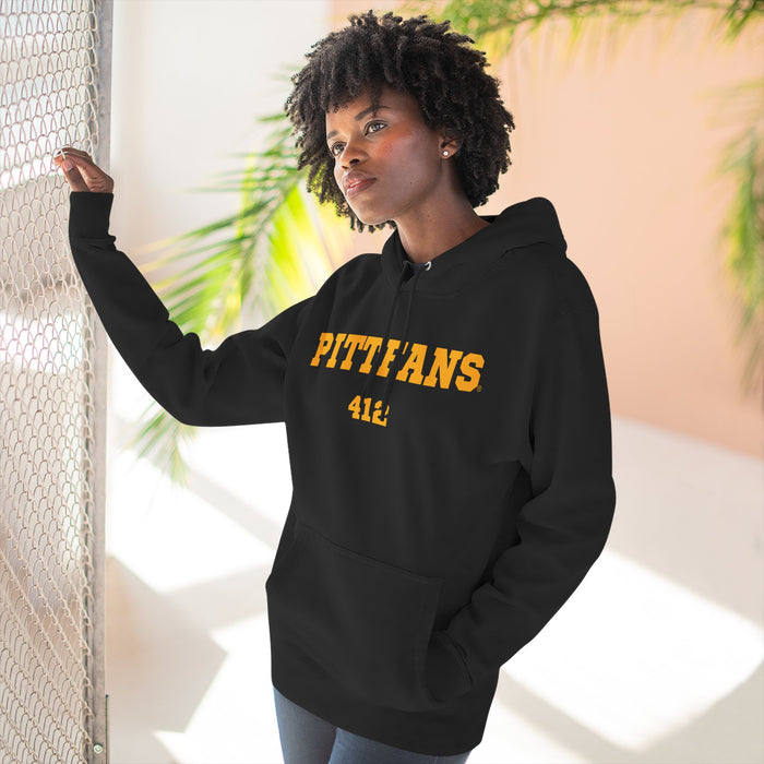 Person wearing a black hoodie with 'PITTFANS' text, standing indoors with plants in the background